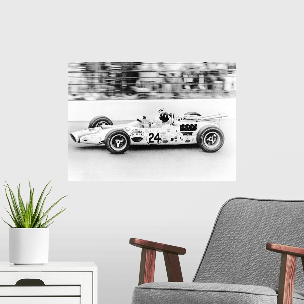A modern room featuring Graham Hill, waves as his car streaks toward the finish line to win the Indianapolis 500. May 30,...
