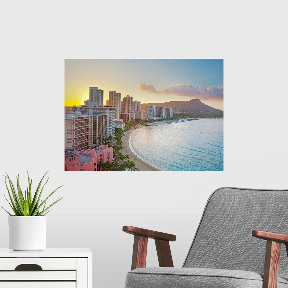 A modern room featuring Landscape photograph on a large wall hanging of the sun rising over buildings along Waikiki Beach...