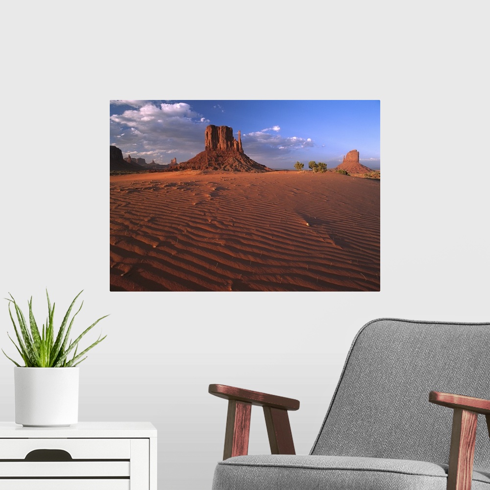 A modern room featuring The Mittens surrounded by rippled sand, Monument Valley Navajo Tribal Park, Arizona