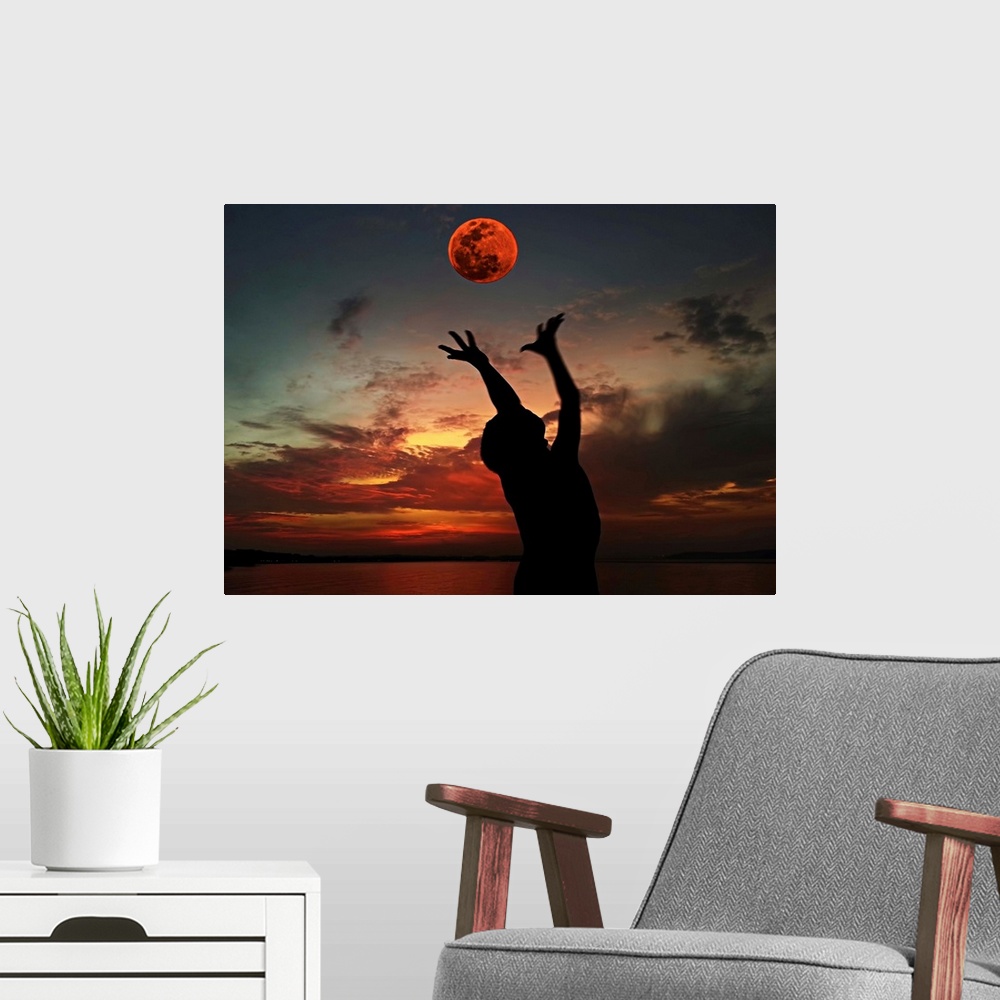 A modern room featuring Silhouette of a person with their arms outstretched towards the red moon in the sky.