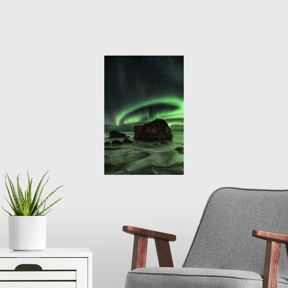 A modern room featuring Ring-shaped aurora borealis over a boulder in the ocean, Norway.