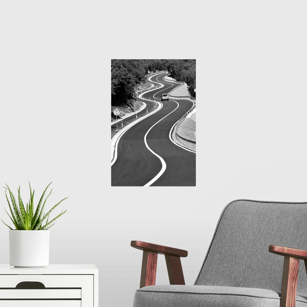 A modern room featuring A car traveling down a stretch of very curvy road.