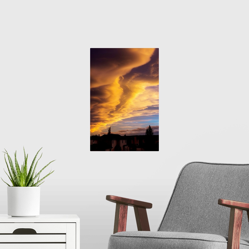 A modern room featuring Dramatic colourful clouds at sunset with interesting formations and some blue sky with houses in ...