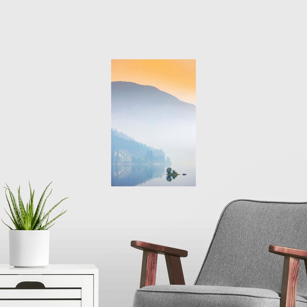 A modern room featuring Dense fog over a lake and mountain with a glowing orange sky at sunrise; British Columbia, Canada