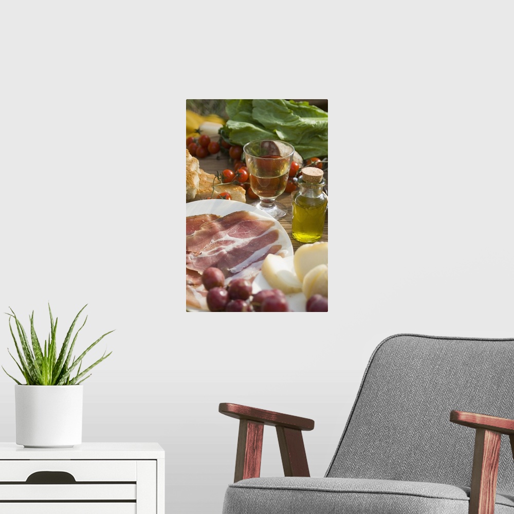 A modern room featuring Prosciutto Ham, Cheese, Tomatoes, White Wine And Other Ingredients For A Picnic In Tuscany, Italy