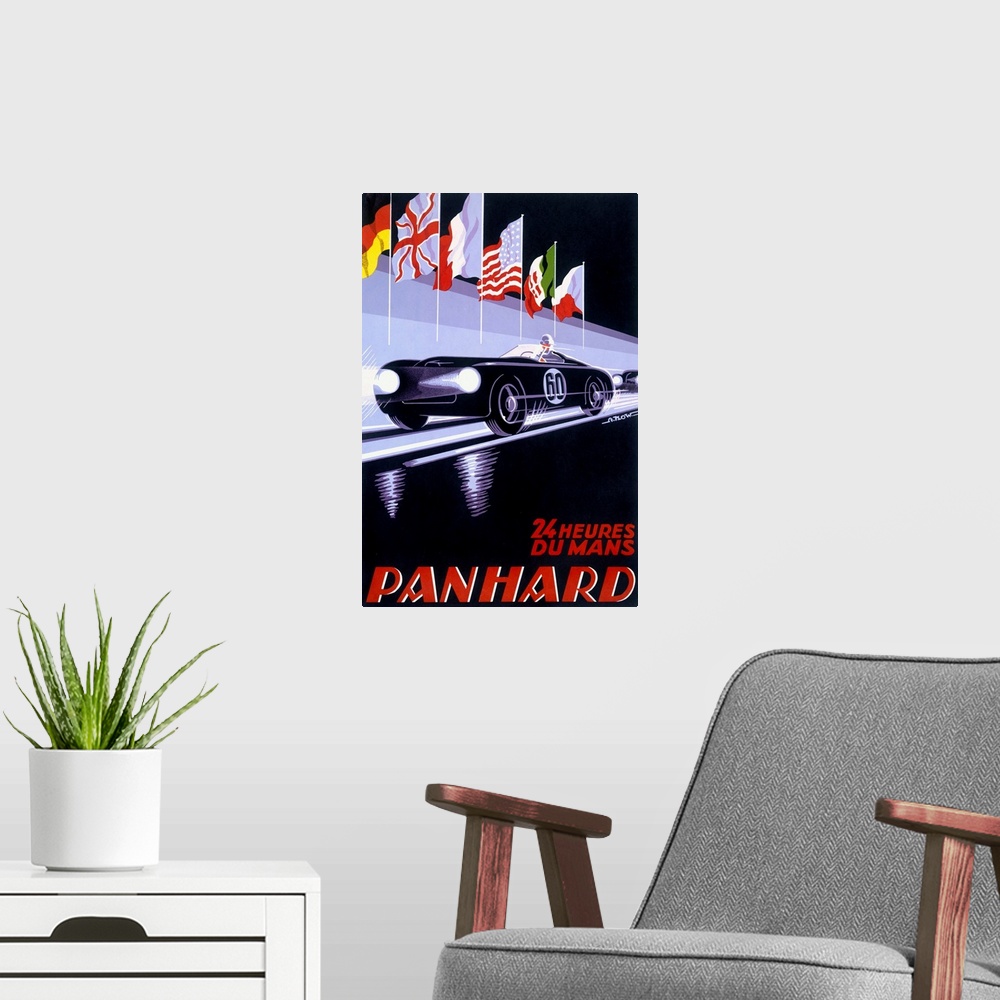 A modern room featuring A vertical piece of artwork of a black car racing with flags above it and red text below with the...