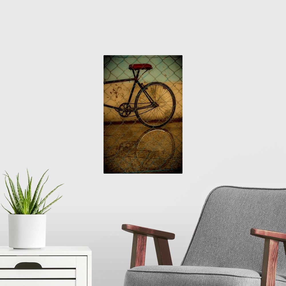 A modern room featuring Photograph of the rear of a bicycle behind a chain link fence with a black vignette.