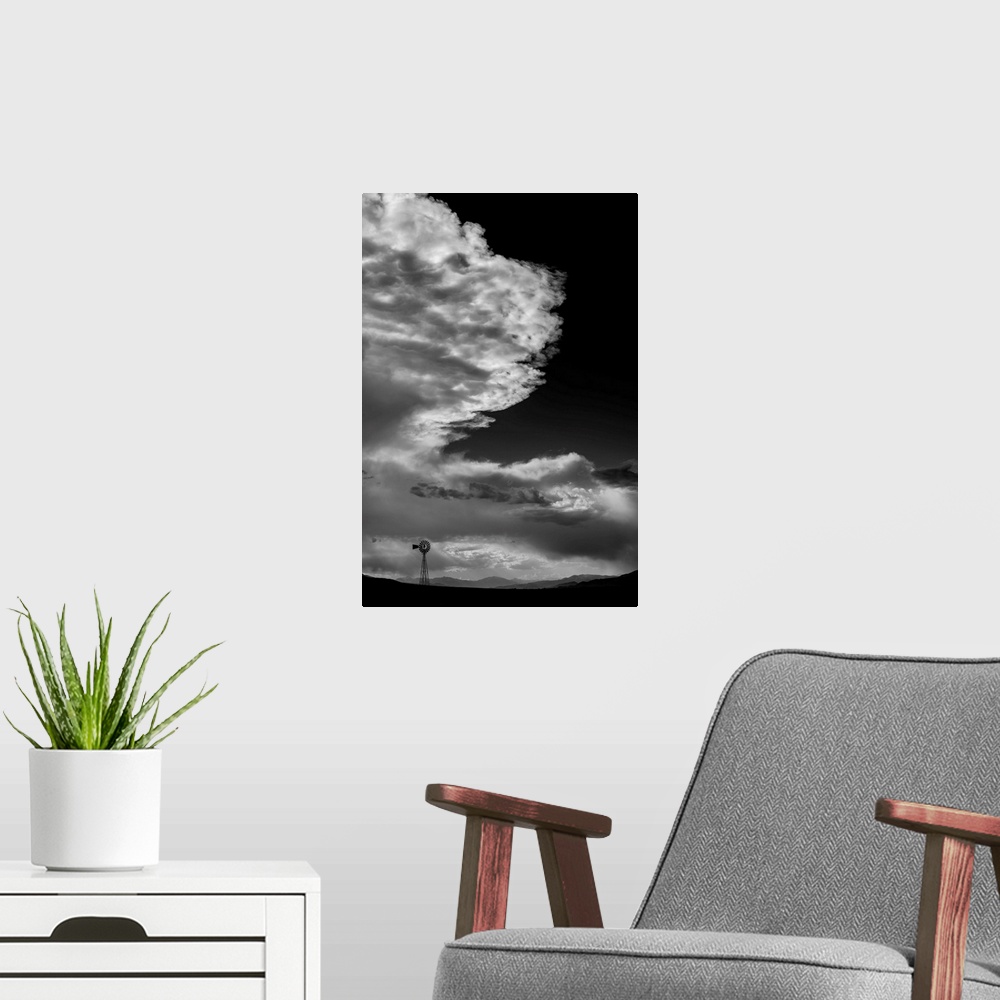 A modern room featuring Black and white photograph of a beautiful cloudy sky with a windmill silhouette in the distance.