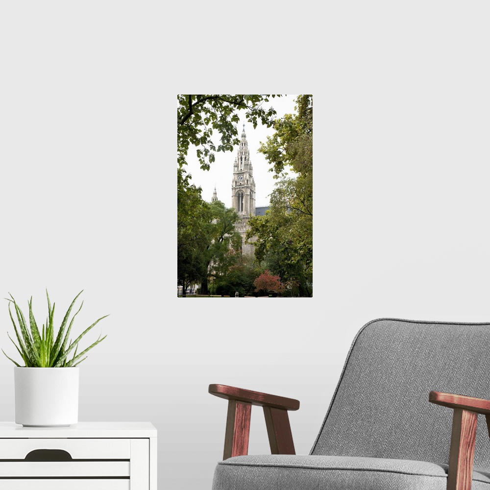 A modern room featuring Vienna, Austria - Low angle view of an ornate, old world church. Trees are framing the building i...