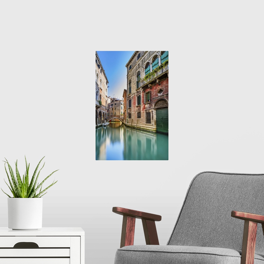 A modern room featuring Venice cityscape, narrow water canal, bridge and traditional buildings. Italy, Europe.