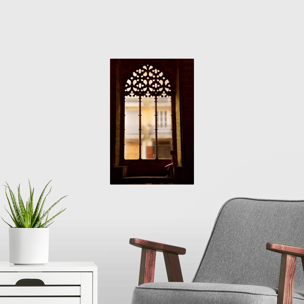 A modern room featuring Spain, Comunidad Valenciana, Valencia, Hall of Lonja de La Seda, Woman sitting by a window
