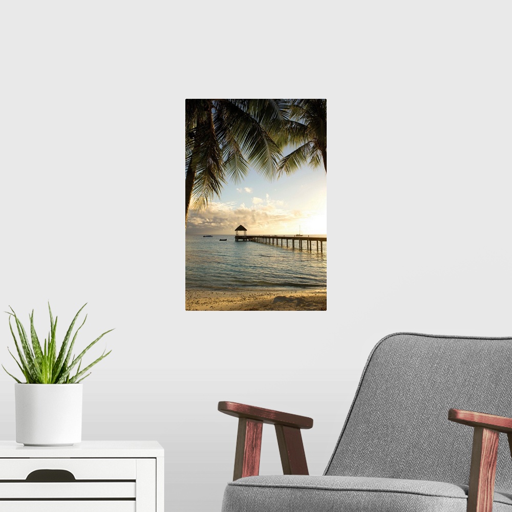 A modern room featuring Vertical photograph of a tropical landscape framed with palm trees on both sides and a long pier ...