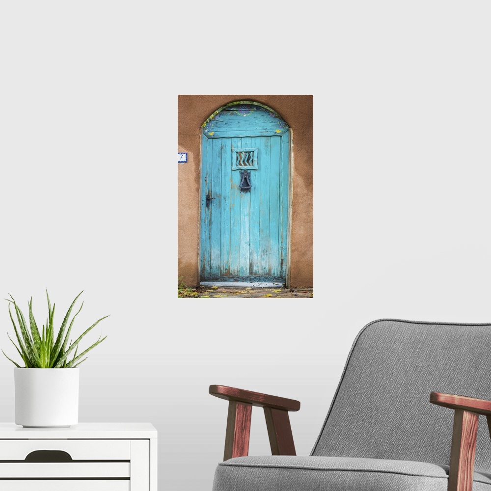 A modern room featuring Photograph of a bright blue door in an adobe wall.