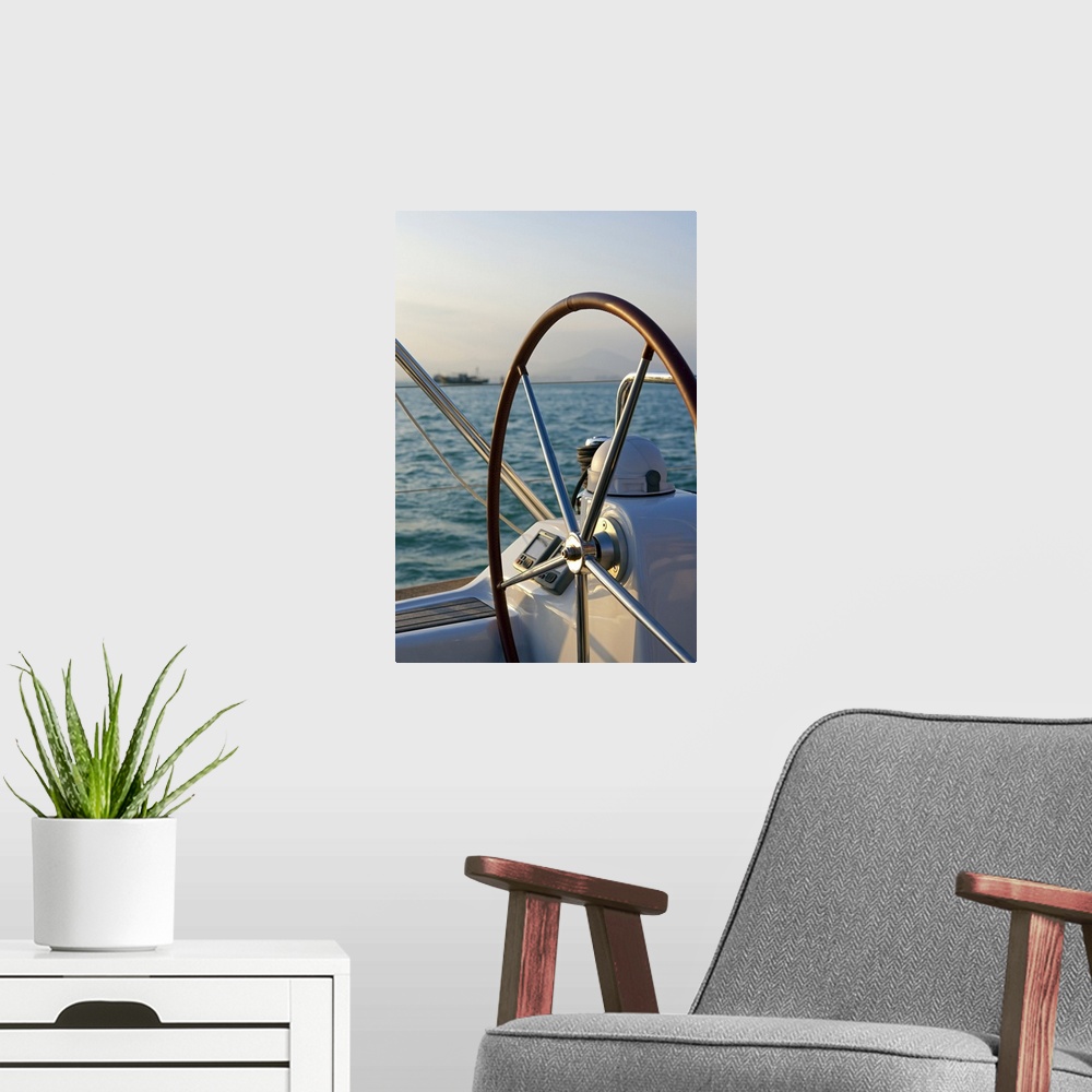 A modern room featuring Up-close photograph of steering wheel on sailboat with the ocean in the background.