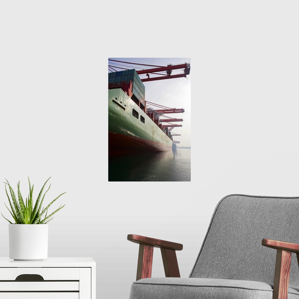 A modern room featuring Cargo ship at port being loaded.