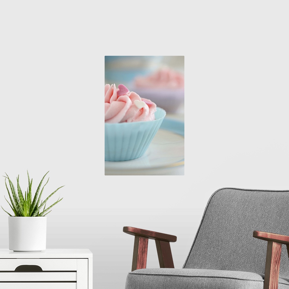 A modern room featuring Cupcakes with pink frosting and hearts of sugar.
