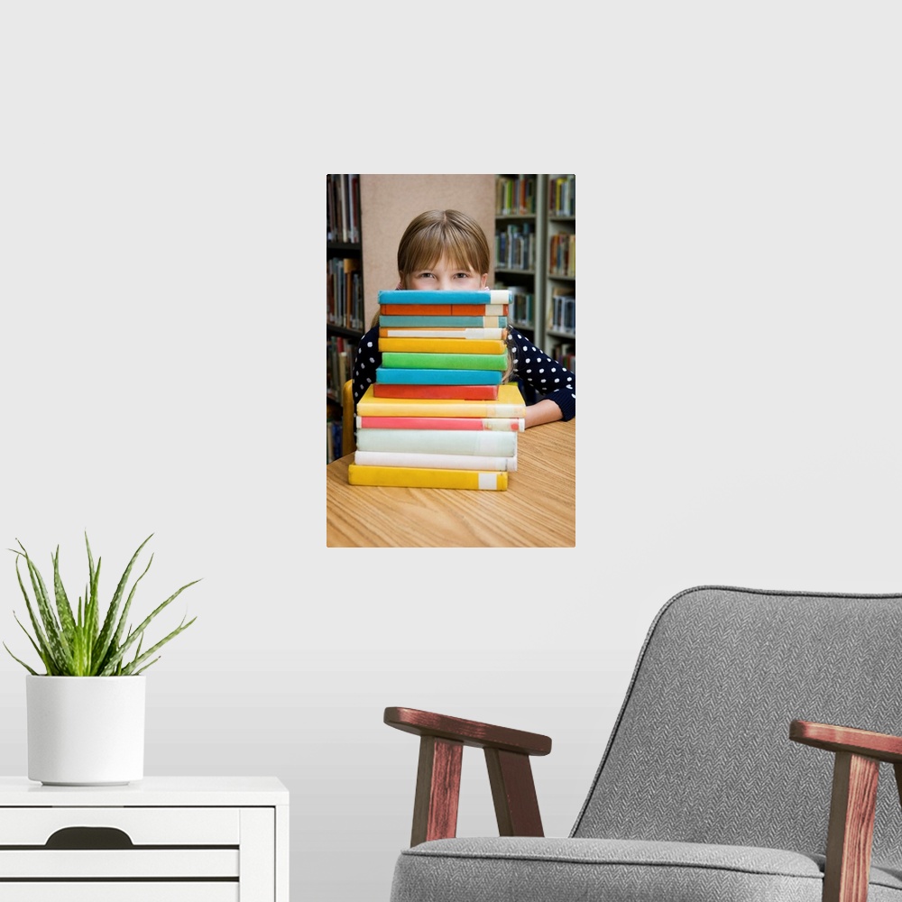 A modern room featuring Girl looking over stack of books