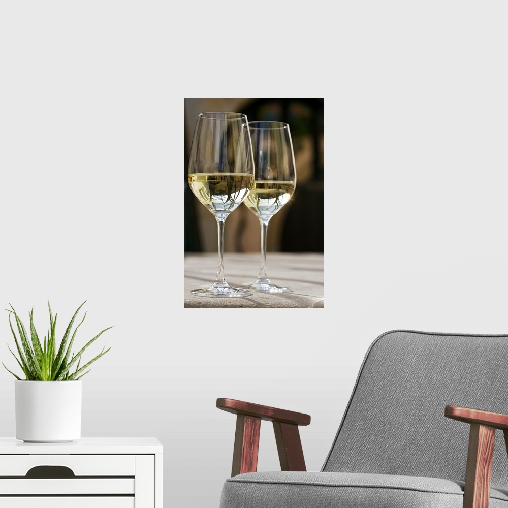 A modern room featuring Up-close photograph of two champagne glasses half full on concrete table.