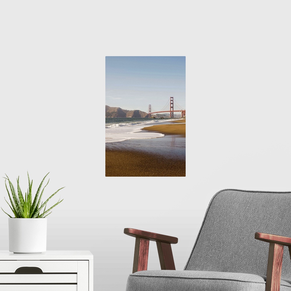 A modern room featuring Vertical photograph taken from a distance of the Golden Gate Bridge which a strip of beach and th...