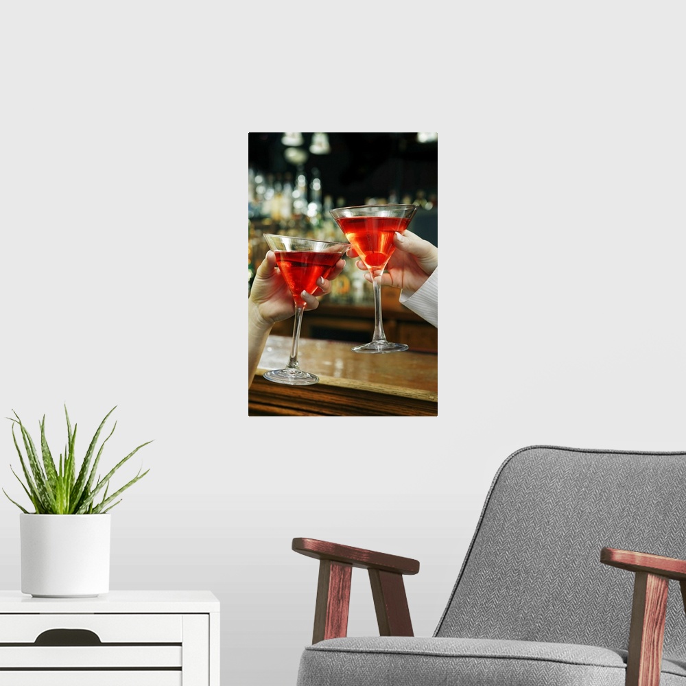 A modern room featuring Hands toasting cosmopolitans