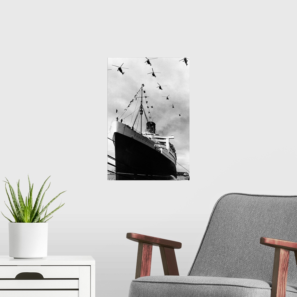 A modern room featuring Royal Navy helicopters fly in formation over the Cunard liner Queen Mary as she leaves Southampto...