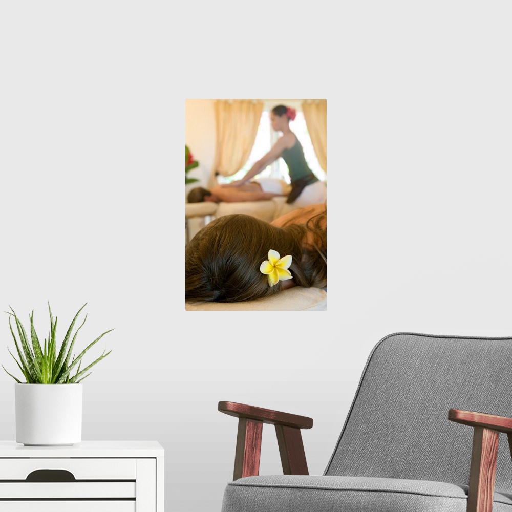 A modern room featuring masseuse massaging young man close up elevated view
