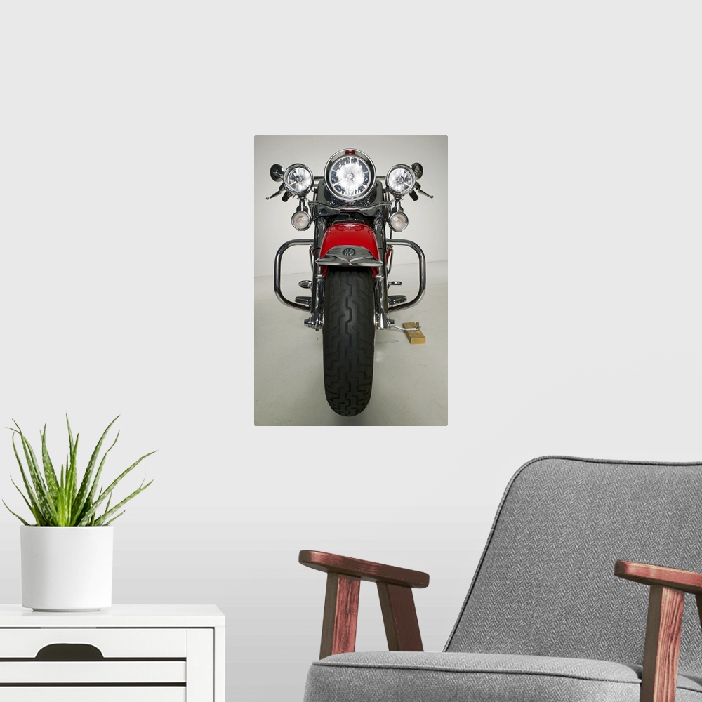 A modern room featuring Vertical photo on canvas of a vintage motorcycle seen from the front.