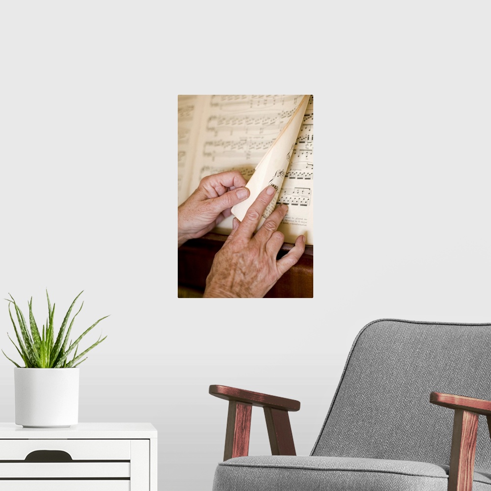 A modern room featuring Senior's hands turning page of sheet music