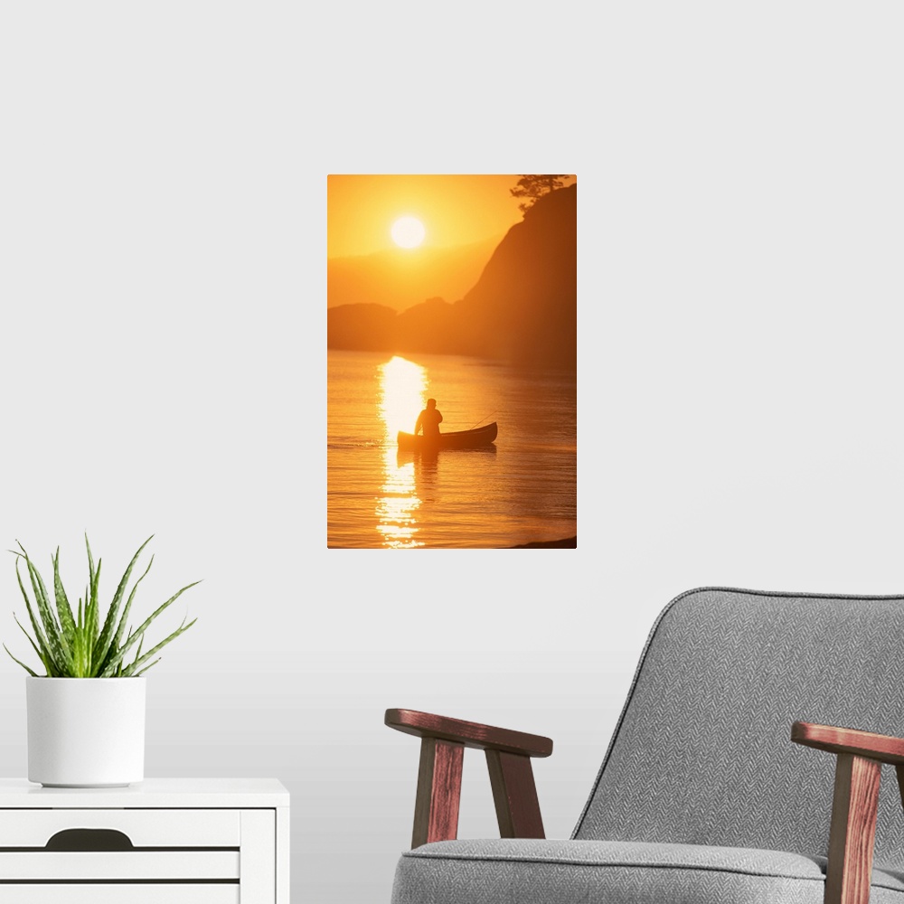 A modern room featuring Silhouette of person canoeing at sunset