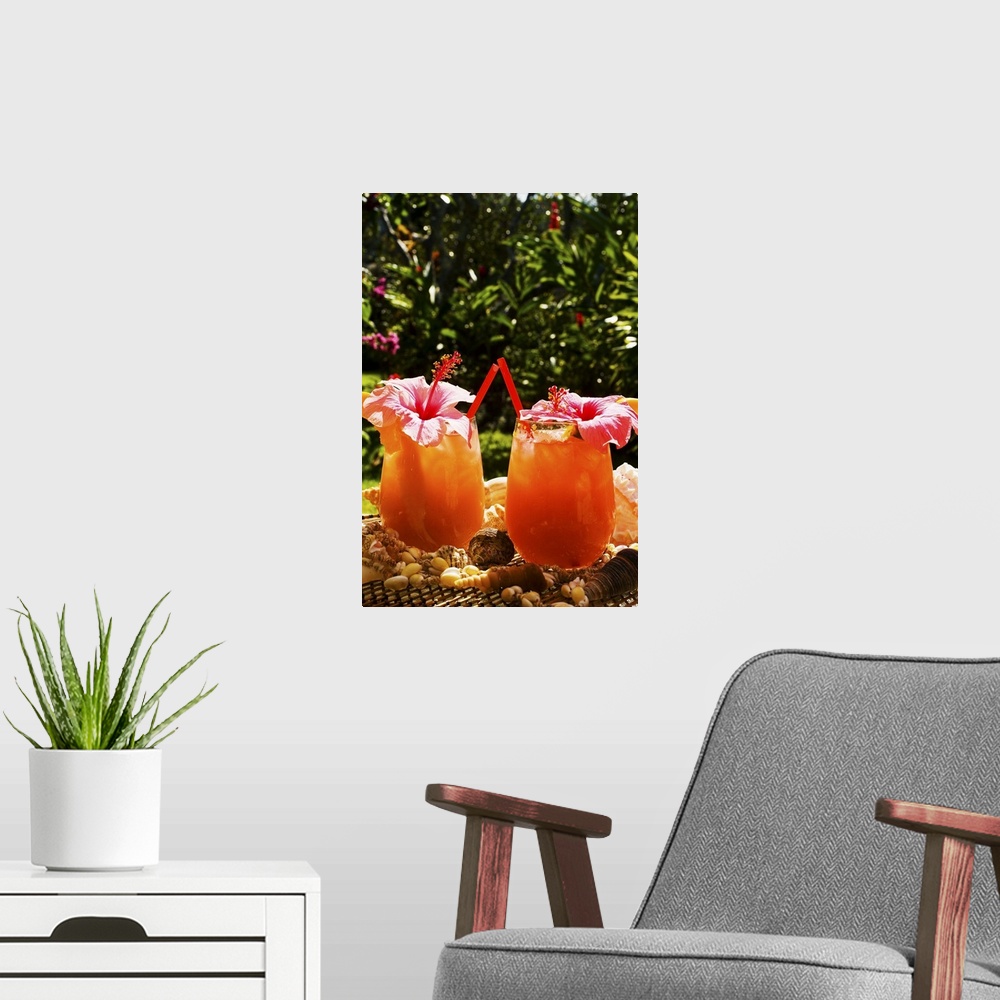 A modern room featuring Two tropical drinks garnished with flowers in an outdoor setting.