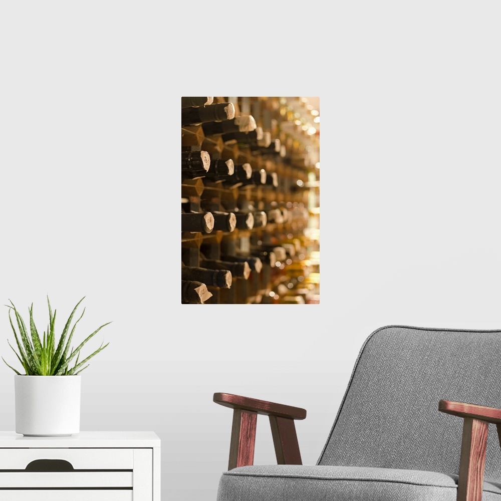 A modern room featuring Artwork perfect for the home of wine bottles stacked in cellar shelves. Taken at an angle so only...