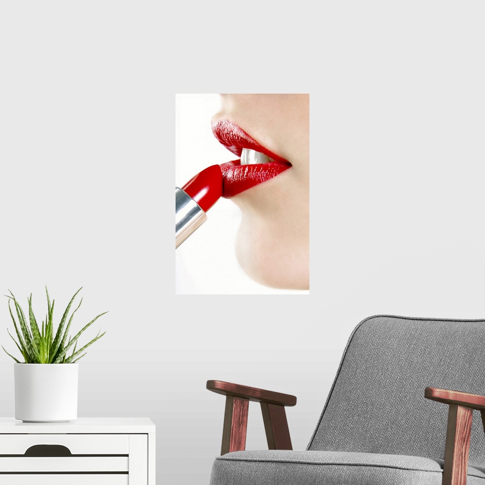 A modern room featuring Up-close photograph of lady putting on colored lip balm from a tube.