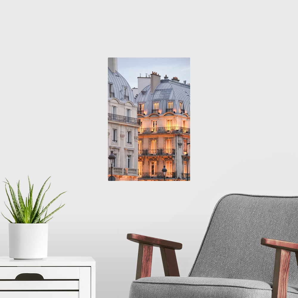 A modern room featuring A photograph of Paris apartment buildings at dusk with lights beginning to warm the faade