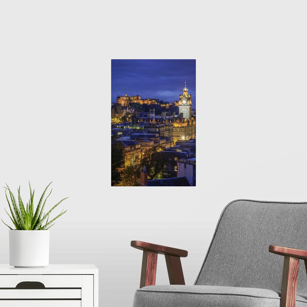A modern room featuring Edinburgh Castle and Balmoral Hotel clock tower viewed from Observatory House in city at dusk, UN...