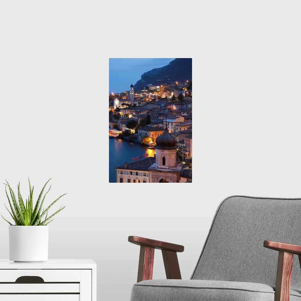 A modern room featuring Italy, Lombardy, Lake District, Lake Garda, Limone sul Garda, aerial town view, dusk