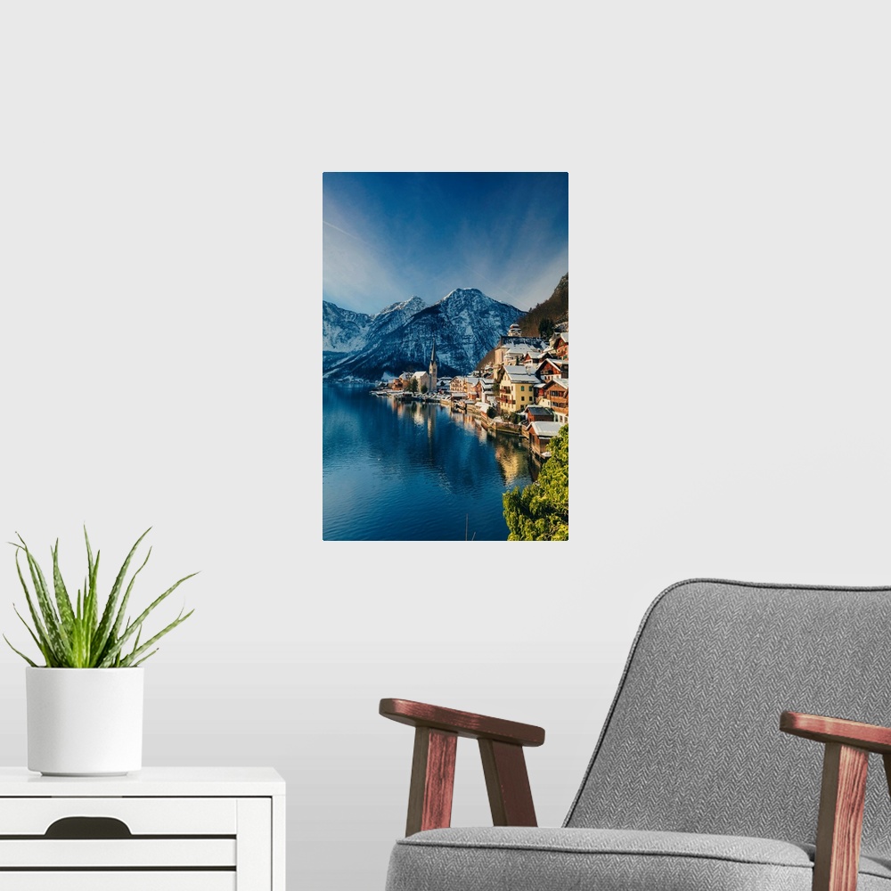 A modern room featuring Typical village called Hallstatt con the Hallstatter see at sunrise with the houses reflecting in...