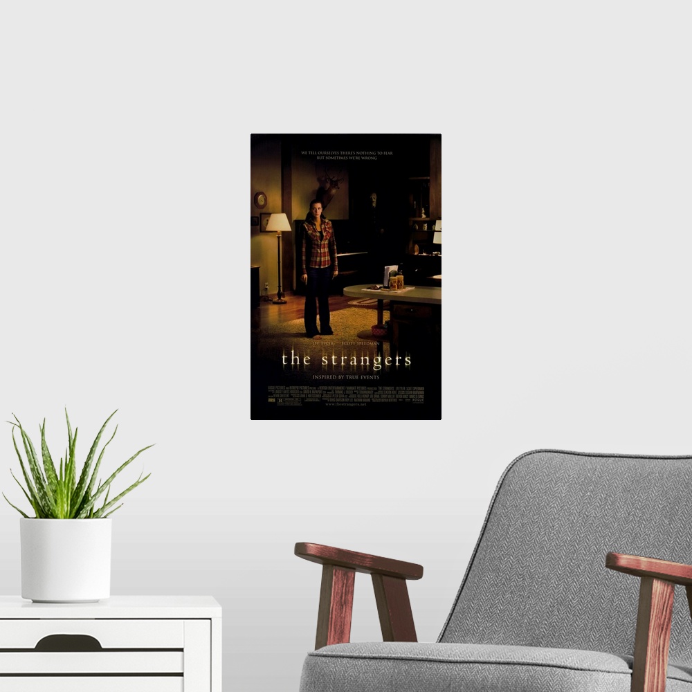 A modern room featuring The Strangers - Movie Poster