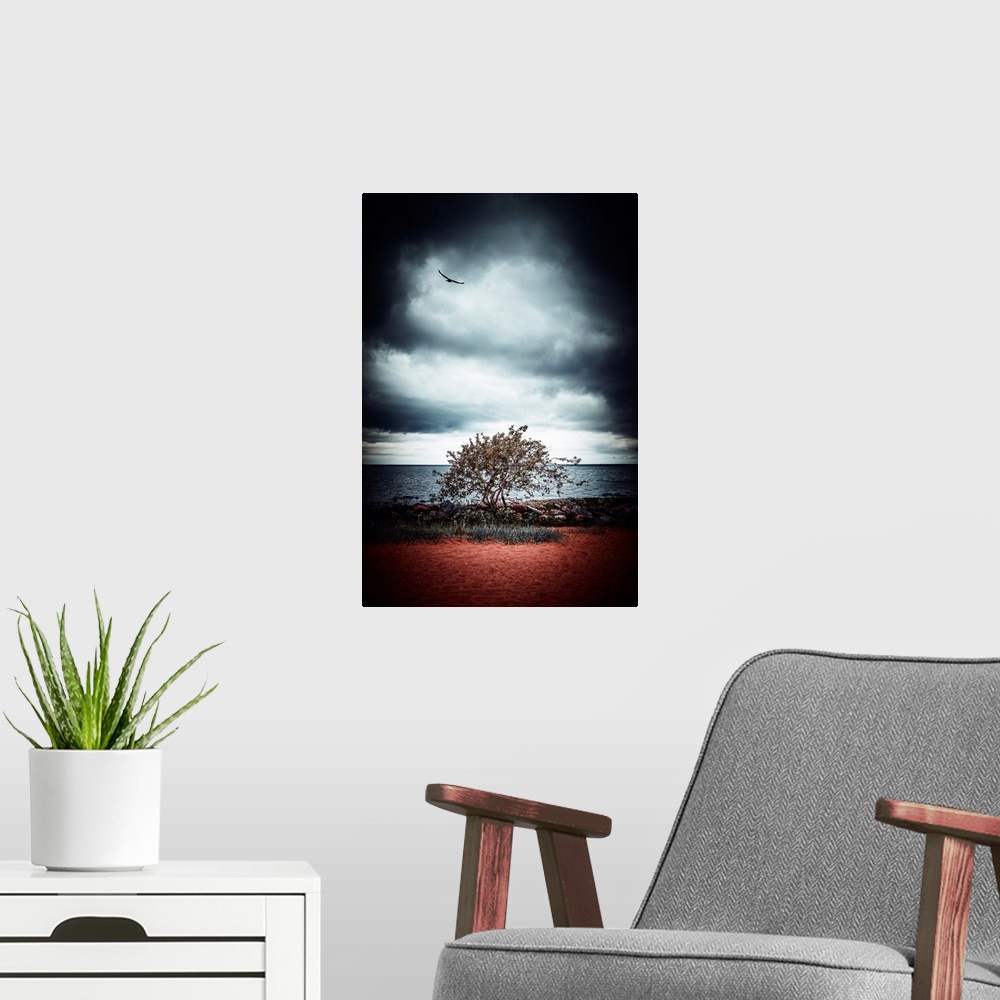 A modern room featuring Stormy sky above a tree by the sea