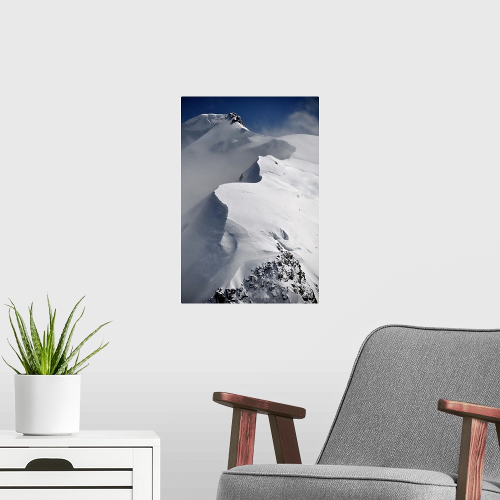 A modern room featuring Mont Blanc du Tacul mountain of the French Alps in France with snow, sun and wind, vertical view.