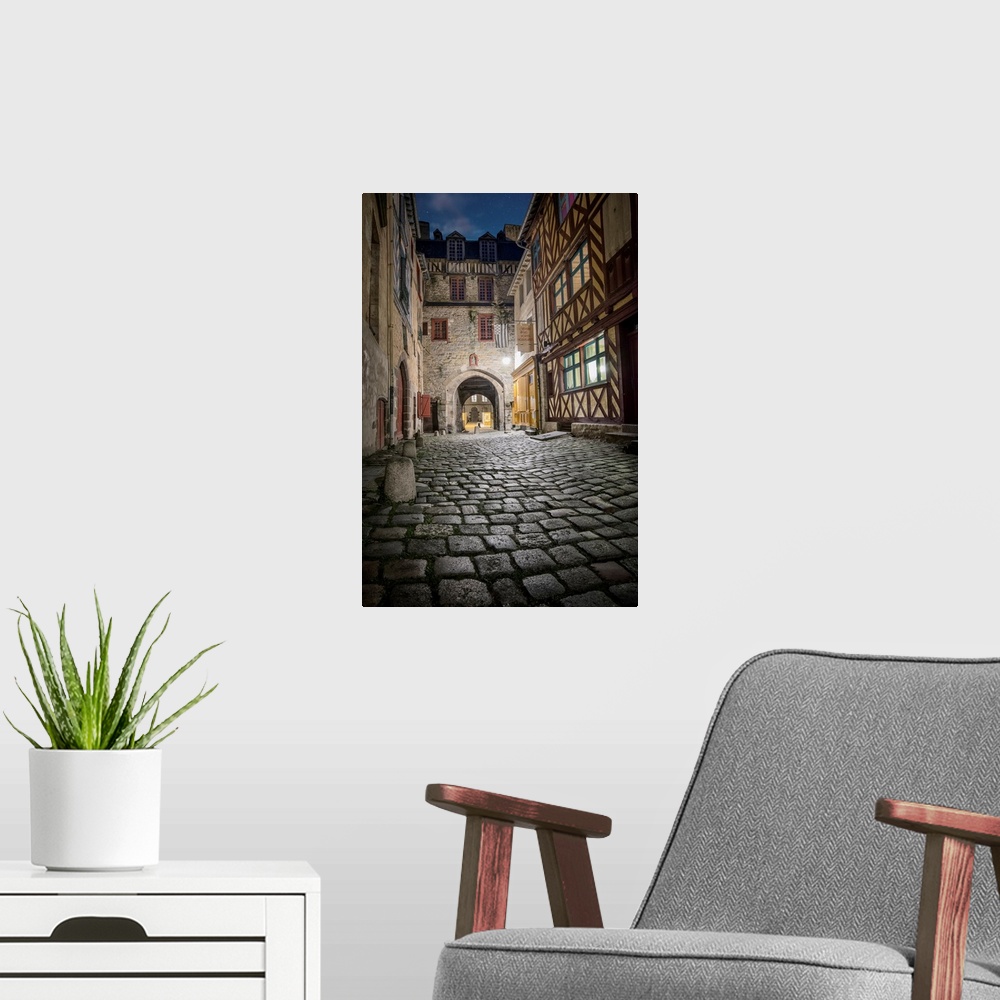 A modern room featuring A photograph looking down the road of a French village.