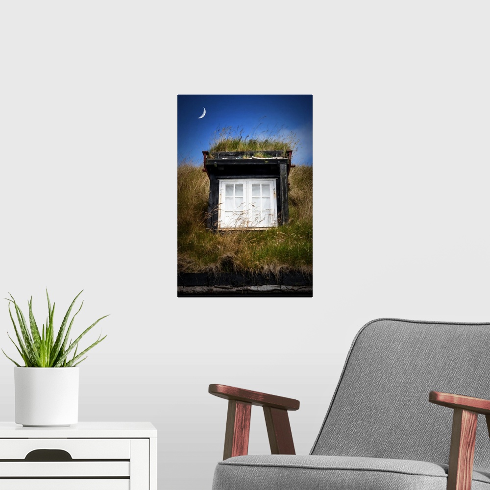 A modern room featuring Crescent moon over a window in the grassy roof of a house.