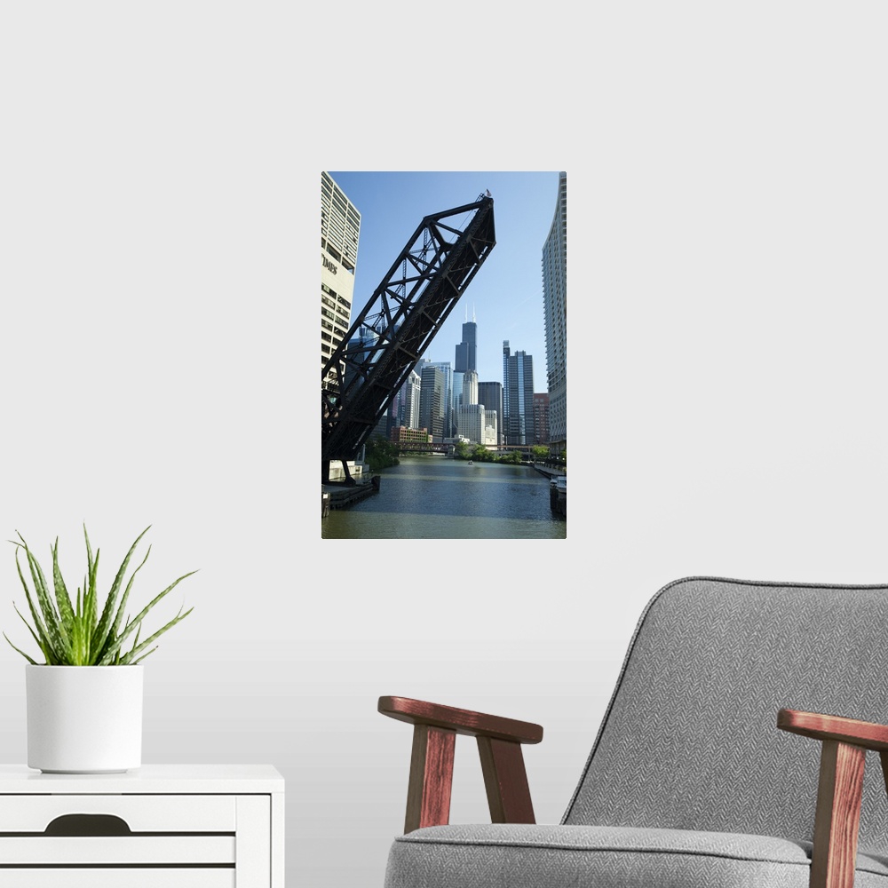A modern room featuring Vertical wall docor of a big bridge raising up on the Chicago River with the Willis Tower in the ...