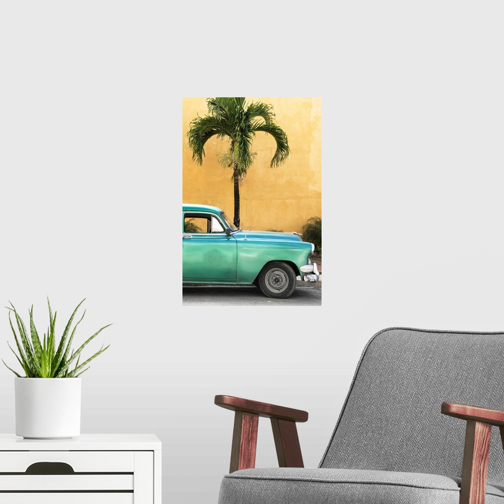 A modern room featuring Photograph of the front half of a vintage green car in front of a palm tree and an orange wall in...