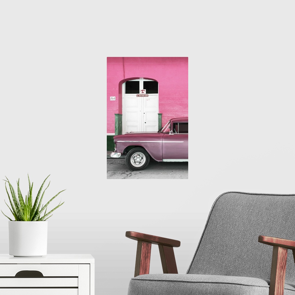 A modern room featuring Vintage pink car parked in front of a pink facade with a white door.