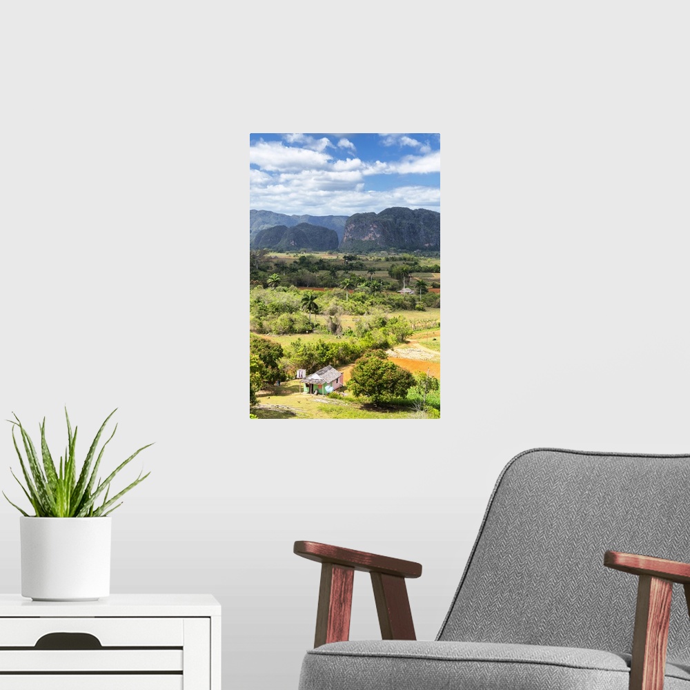 A modern room featuring Vertical landscape photograph of  Vinales Valley in Ciba with a green and pink hut in the foregro...