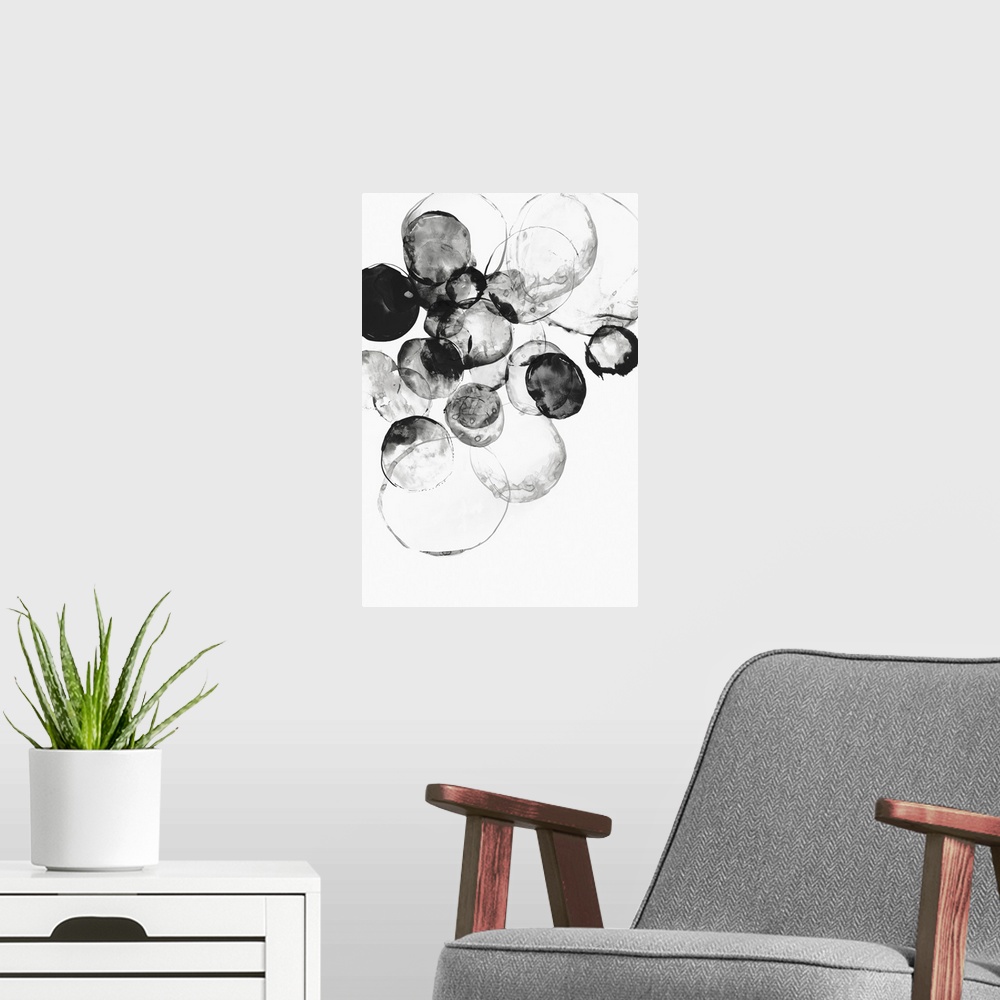 A modern room featuring Large vertical painting of black circular shapes on white.