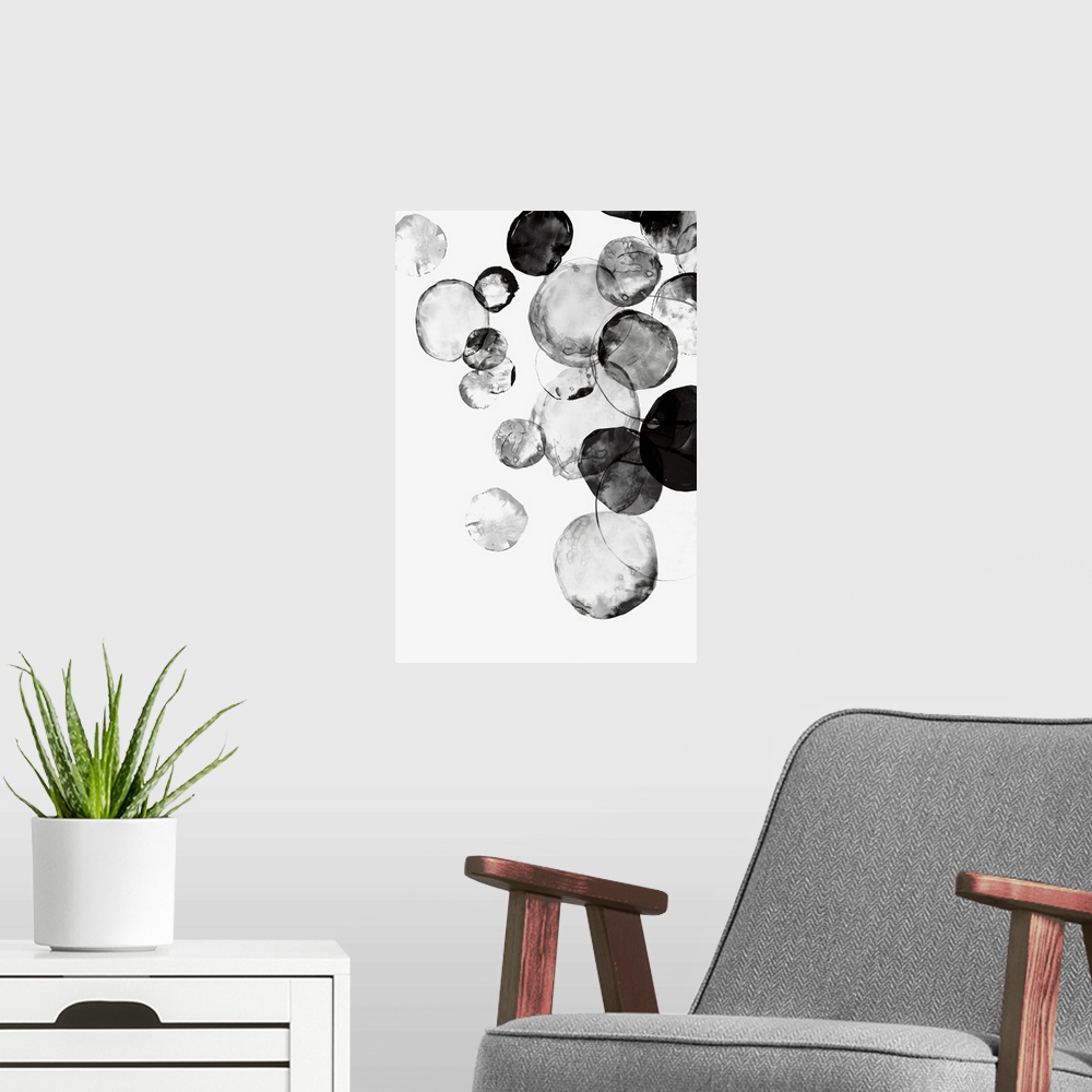 A modern room featuring Large vertical painting of black circular shapes on white.
