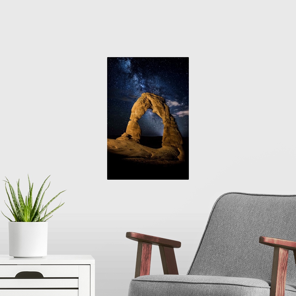 A modern room featuring Delicate Arch in Arches National Park, Utah, under a starry night sky.