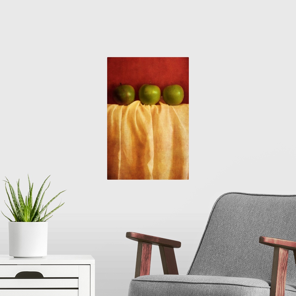 A modern room featuring Still life with three granny smith apples against red background
