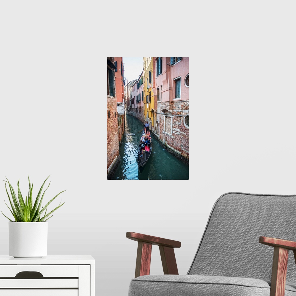 A modern room featuring Photograph of a gondola rowing though a canal surrounded by colorful building facades in Venice, ...